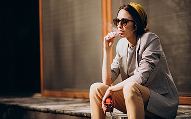 Young woman sitting and smoking ecigarette